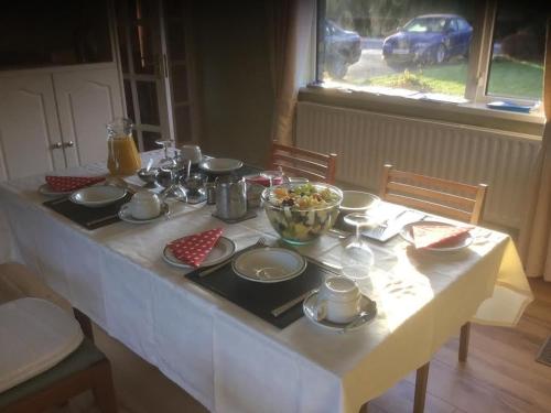 库特希尔Hillview House的一张桌子,上面有白色的桌布和一碗食物