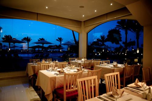拉斯苏德尔Mousa Coast Hotel & Spa的一间设有桌椅的海景餐厅