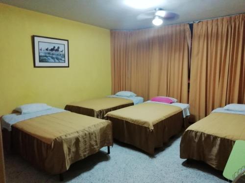 齐克拉约Hospedaje Oasis的一间房间,有三张床
