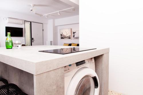 雅典Vouliagmeni Art Micro Loft的厨房以及带洗衣机的起居室。