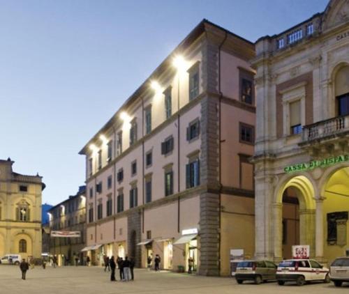 卡斯泰洛城Appartamento Palazzo Bufalini的一座大型建筑,前面有人