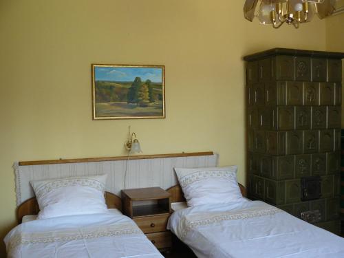 NagyrákosŐrségi Gorza Vendégház的卧室配有两张床,墙上挂着一幅画
