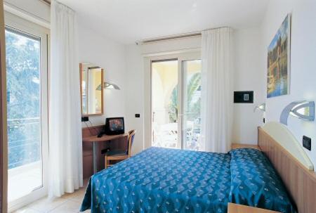 阿尔巴·阿德里亚蒂卡Residence Le Palme的一间卧室配有一张床、一张书桌和一个窗户。