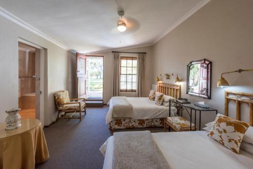 MatjiesfonteinLord Milner Hotel的酒店客房带两张床和一间浴室