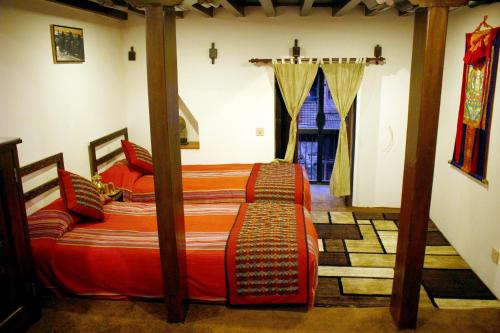 加德满都府庙乡村别墅的一间卧室设有两张单人床和一个窗户。