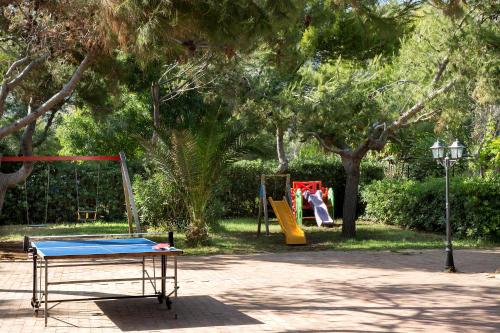 加埃塔Torre San Vito Hotel Villaggio的一个带乒乓球桌和秋千的公园
