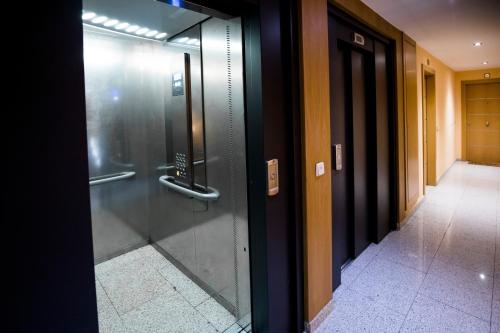 安道尔城Confort Escaldes的走廊上的大楼内玻璃电梯门