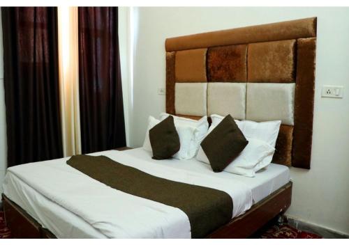钱德加尔Inderlok Hotel的一间卧室配有带白色床单和枕头的床。