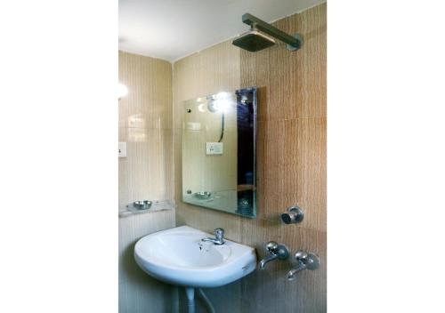 钱德加尔Inderlok Hotel的一间带水槽和镜子的浴室