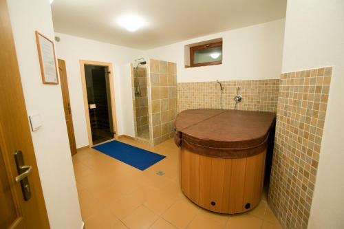 塔查斯卡-鲁穆尼卡Penzión Paula的一间带大型木制浴缸和淋浴的浴室