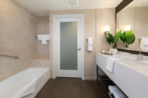 汉诺瓦阿伦德尔保护区酒店的带浴缸、水槽和镜子的浴室