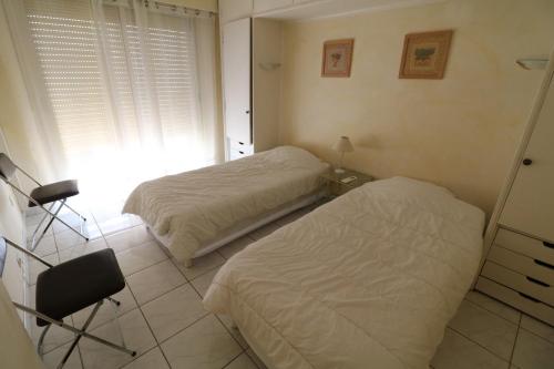 戛纳2 bedroom, 2 bathrooms, 2 mins from the Croisette, Monod 348的一间卧室配有两张床、一张桌子和一把椅子