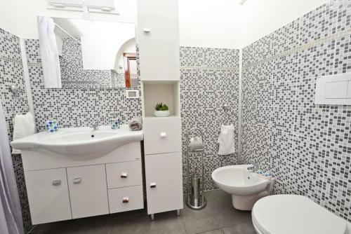 奥斯图尼Casa Victoria的白色的浴室设有水槽和卫生间。