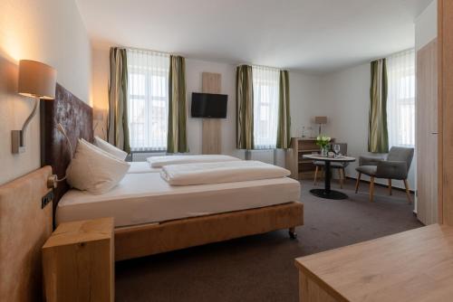 伊普霍芬Gasthof & Hotel Goldene Krone的酒店客房设有一张大床和一张书桌。