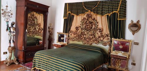 巴勒莫维奥拉宫公寓的一间卧室配有华丽的床和镜子