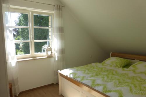 罗埃特根Ferienwohnung am Eifelsteig的一间卧室设有一张床和一个窗口
