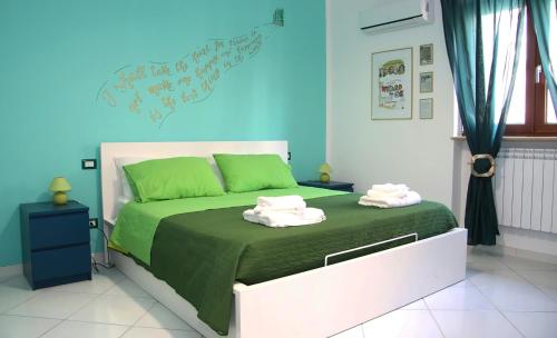 泰卡斯MarArte B&B的卧室配有绿色和白色的床,提供毛巾