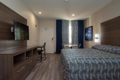 埃尔帕索Palace Inn El Paso的配有一张床和一张书桌的酒店客房