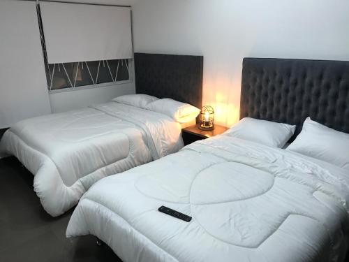波哥大Hotel OrangeTrip的酒店客房设有两张床,并配有遥控器