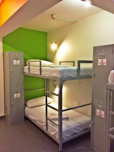 新加坡Campbell Inn的带三张双层床和绿色墙壁的客房