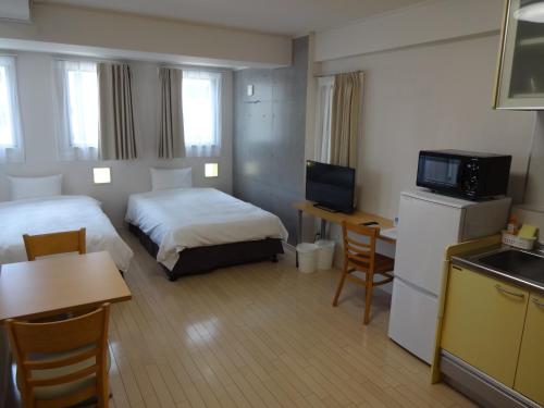 那霸Across Omoromachi Naha的酒店客房设有两张床和电视。
