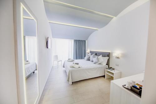 切法卢Ossuna Bay Hotel Boutique的白色卧室配有床和桌子