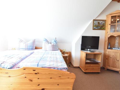 佩佩洛Nice holiday room in Pepelow on the Baltic Sea的一间卧室配有一张床,木制橱柜上配有电视