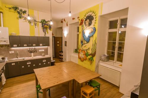 布拉格The MadHouse Prague的厨房配有桌子,墙上挂有绘画作品