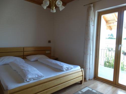 考那亚诺Fasslhof的一间卧室设有一张床和一个大窗户