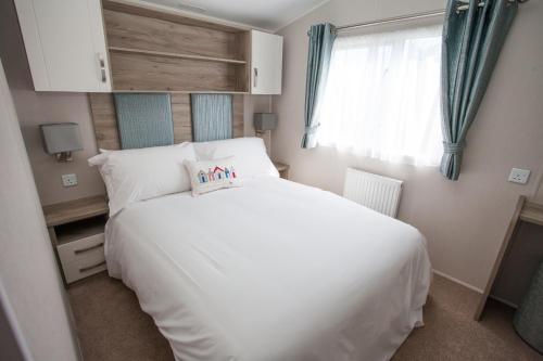 库伯特Little treamble holidays的卧室配有白色的床和窗户。