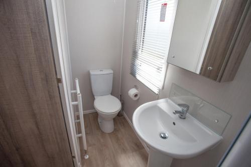库伯特Little treamble holidays的浴室配有白色卫生间和盥洗盆。