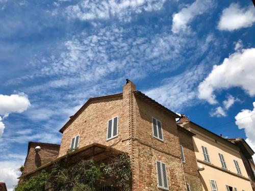 皮耶韦城B&B Casa Gaia的一座砖砌建筑,背景是一片云天