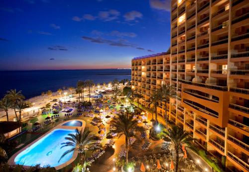 贝纳尔马德纳日落海滩俱乐部公寓酒店的享有酒店夜间游泳池的景色