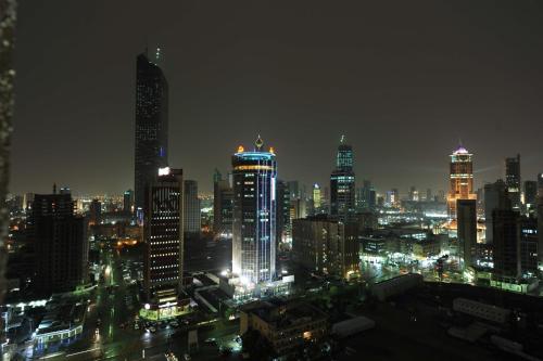 科威特Millennium Central Kuwait Downtown的城市天际线,夜晚有灯光的建筑