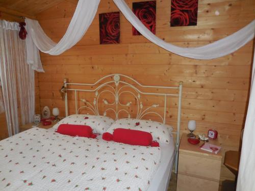 曼杜里亚Casetta Piccola Strega的卧室配有带红色枕头的白色床