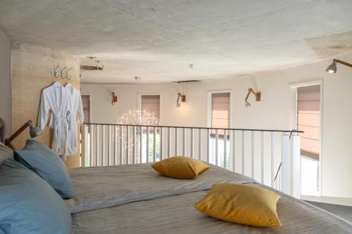Nes内斯瓦特托勒酒店的一间卧室配有一张带黄色枕头的床。