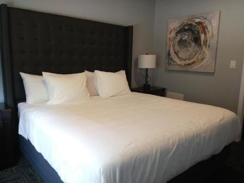 沃萨加比奇海滩Wasaga Riverdocks Hotel Suites的一张大白色的床,位于酒店客房内