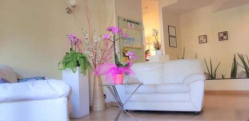 文蒂米利亚普旺萨酒店的客厅配有白色沙发和带紫色花卉的桌子