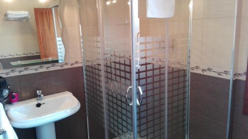 克尤拉斯罗萨斯公寓的一间带水槽和玻璃淋浴的浴室