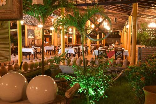 巴雷里尼亚斯普雷格伊萨斯港度假酒店的一间设有桌椅的餐厅,种植了植物