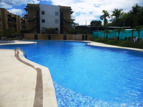 拉特瓦伊达ApartaSol Reserva de la Colina的一座大型蓝色游泳池,位于大楼旁边