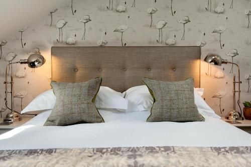 卡莱尔The Halston Carlisle的卧室配有一张带白色床单和枕头的大床。