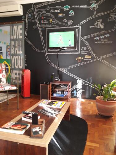 巴乌鲁Casa Beatles Hostel Bauru的客厅设有黑色墙壁,上面有地图