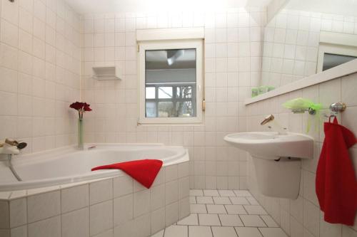 罗斯托克Urlaub im Wintergarten Rostock-Lichtenhagen-Dorf的白色的浴室设有浴缸和水槽。