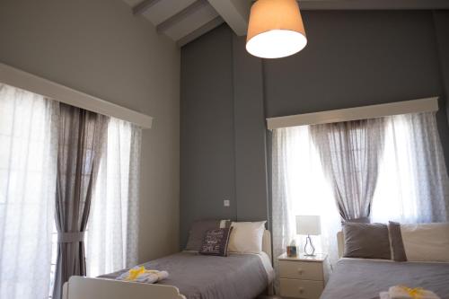 阿尔加卡Limone Villas No 3的一间卧室设有两张床和两个窗户。