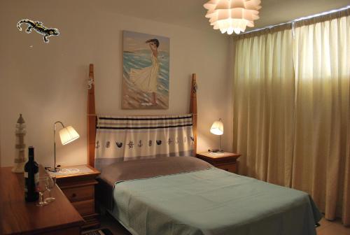 圣地亚哥港La Arena Beach的一间卧室配有一张床、两盏灯和一个窗户。