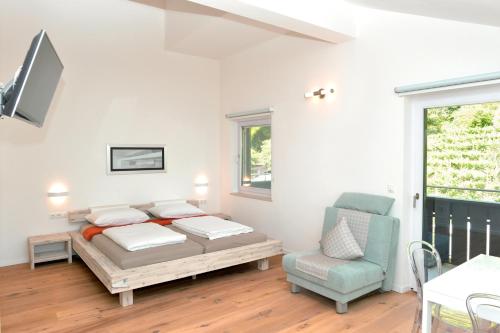 Magrè allʼ AdigeTraubenhof的卧室配有床、椅子和窗户。