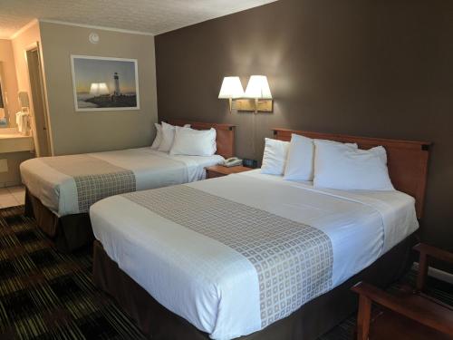 桑达斯基南岸酒店的酒店的客房 - 带2张带白色枕头的床