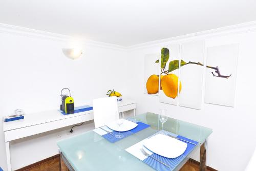 卡普里La Perla Blu的白色的用餐室配有蓝色的桌子和白色的柜台。