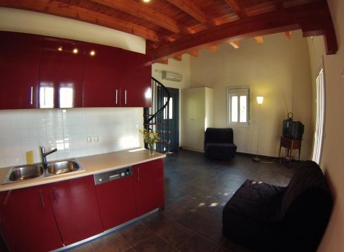 瓦西利基Casa Nostos的一间带红色橱柜和水槽的厨房